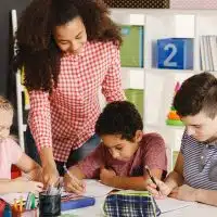 Class working with teacher during lesson in school